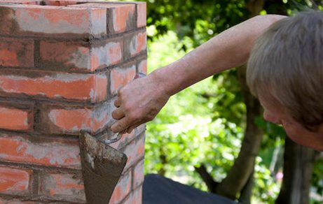 Trowel working fresh mortar into aging joints